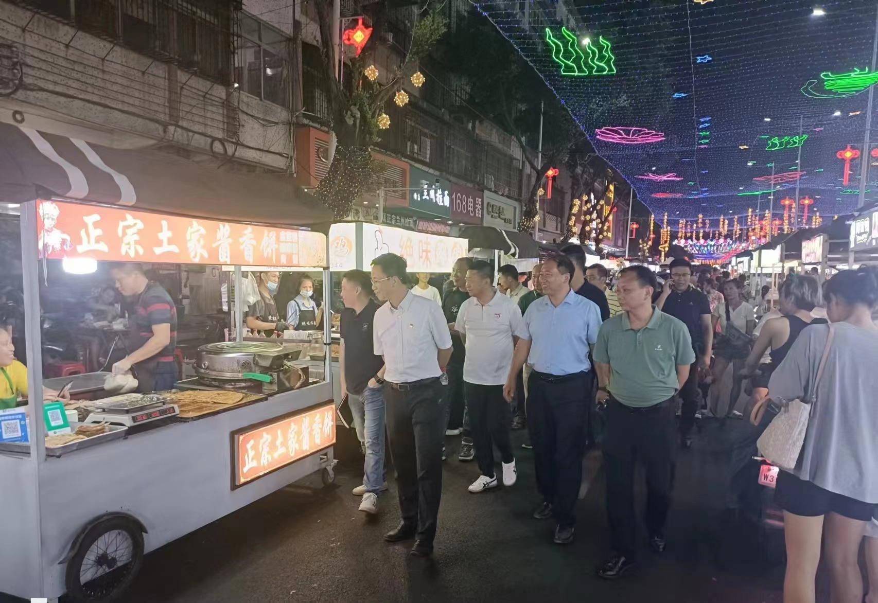 图为吴勐、曾伟雄、陈小刚、许有彬等代表察看两龙夜市经营情况.png